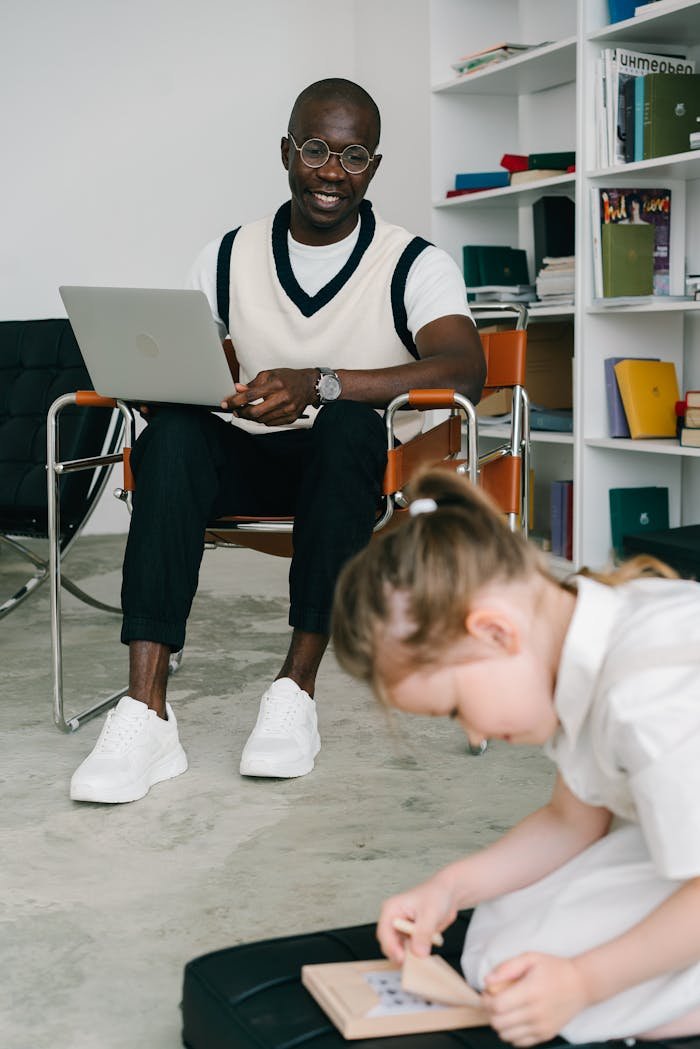 Therapist observing a child engaged in educational activity indoors.